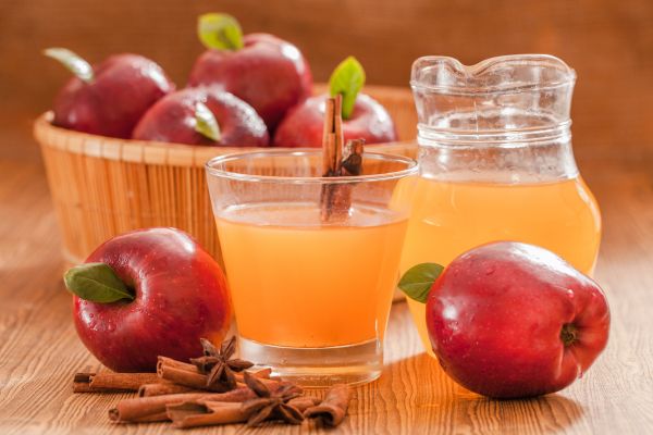 Apfelessig Äpfel im korb und apfelsaft in glaesern
